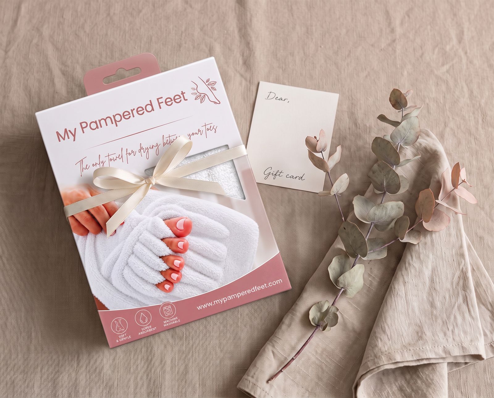 Toe Dry Towel box tied with a cream ribbon beside a gift card